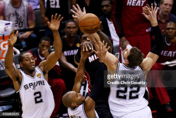 LeBron James of the Miami Heat makes a pass as Kawhi Leonard, Patty Mills, and Tiago Splitter of the San Antonio Spurs defend during Game Five of the...