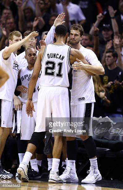Tim Duncan celebrates with Tiago Splitter of the San Antonio Spurs on the bench against the Miami Heat during Game Five of the 2014 NBA Finals at the...