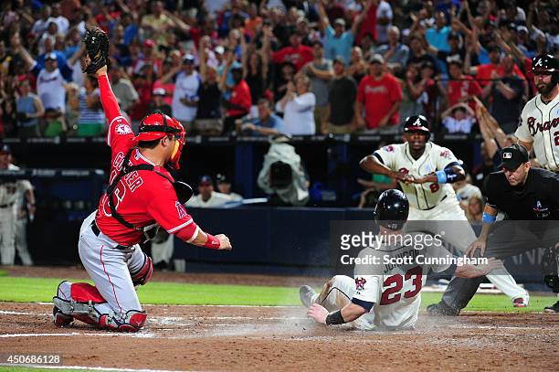 Chris Johnson of the Atlanta Braves is tagged out at home in the 6th inning by Hank Conger of the Los Angeles Angels of Anaheim at Turner Field on...