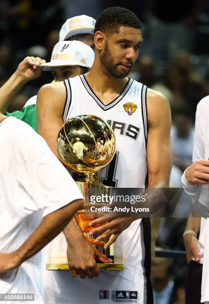 Tim Duncan of the San Antonio Spurs holds the Larry O'Brien trophy on the fourt after defeating the Miami Heat in Game Five of the 2014 NBA Finals at...