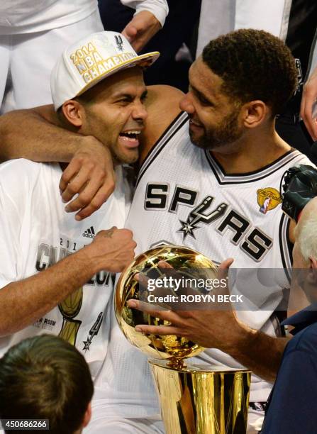 Tony Parker and Tim Duncan of the San Antonio Spurs celebrate with the Larry O'Brien NBA Championship Trophy after the Spurs defeated the Miami Heat...