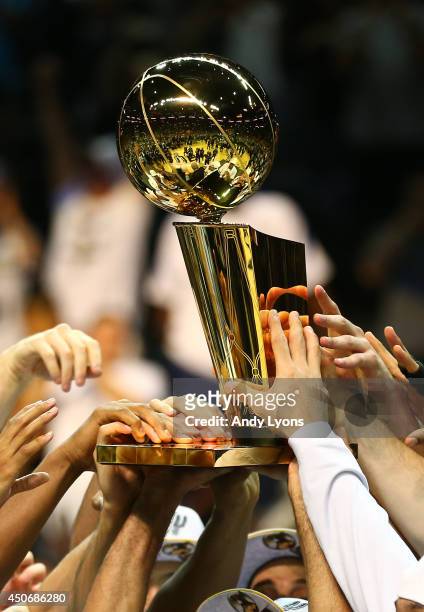 The San Antonio Spurs celebrate with the Larry O'Brien trophy after defeating the Miami Heat to win the 2014 NBA Finals at the AT&T Center on June...