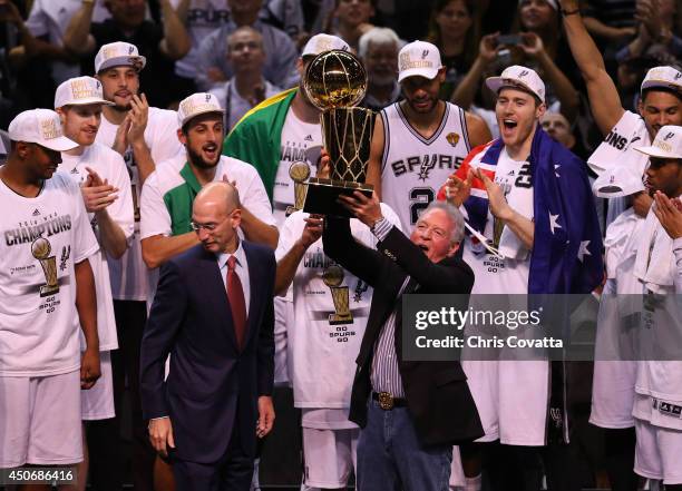 San Antonio Spurs owner Peter Holt celebrates with the Larry O'Brien trophy after defeating the Miami Heat to win the 2014 NBA Finals at the AT&T...