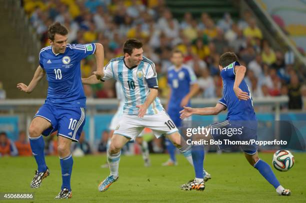 Lionel Messi of Argentina challenged by Zvjezdan Misimovic and Miralem Pjanic of Bosnia-Herzegovina during the 2014 FIFA World Cup Brazil Group F...