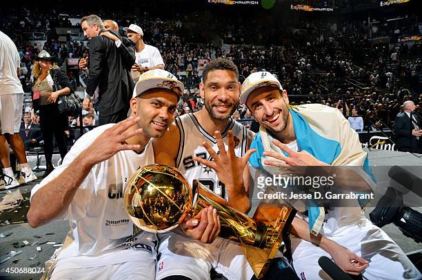 Manu Ginobili, Tony Parker, and Tim Duncan of the San Antonio Spurs celebrate with the Larry O'Brien trophy after defeating the Miami Heat to win the...