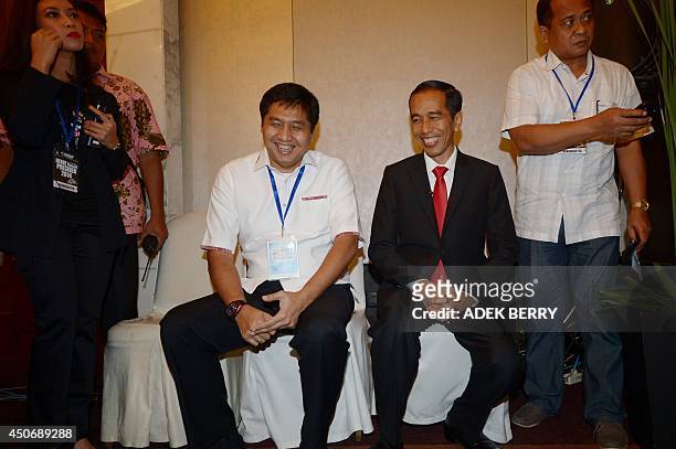 This picture taken in Jakarta on June 15, 2014 shows Indonesian presidential candidate Joko Widodo sharing a light moment with his aid from PDI-P,...