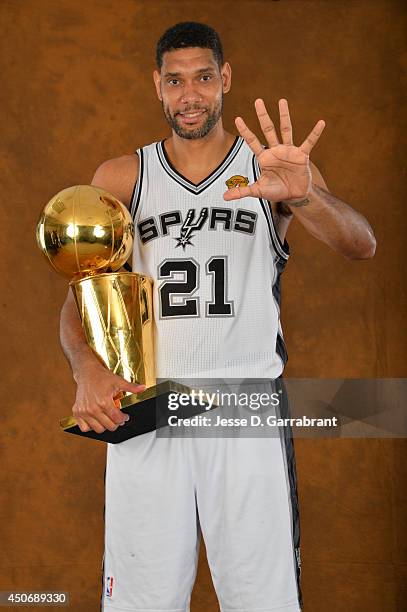 TIm Duncan of the San Antonio Spurs poses for a portrait with the Larry O'Brien Trophy after defeating the Miami Heat in Game Five of the 2014 NBA...