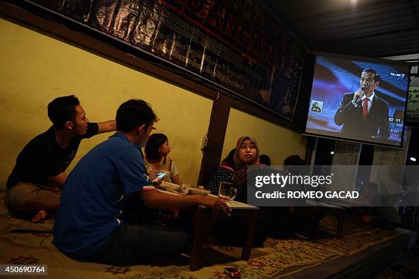 In this photograph taken on June 15 customers at a restaurant watch a live broadcast of the one on one debate between Indonesian presidential...