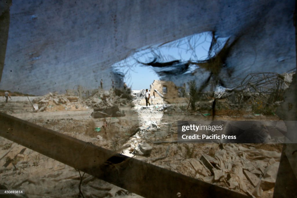 A Palestinian walks past the aftermath of an Israeli air...