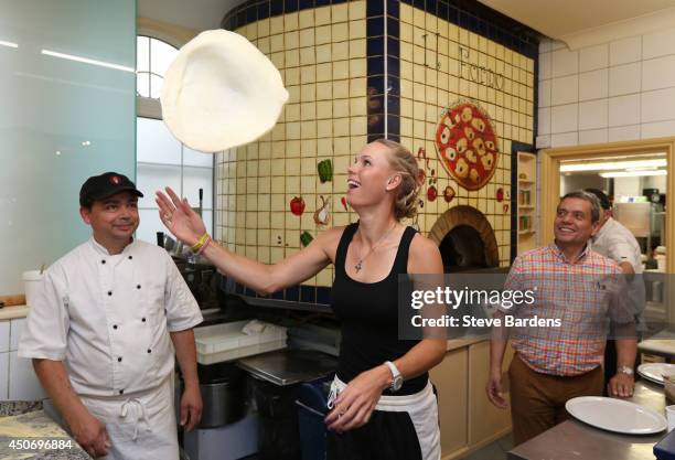 Caroline Wozniacki of Denmark makes a pizza at Pomodore e Mozzarella ristorante in Eastbourne on day two of the Aegon International at Devonshire...