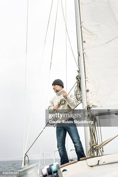 mature man on sailingboat - sailingboat stock-fotos und bilder