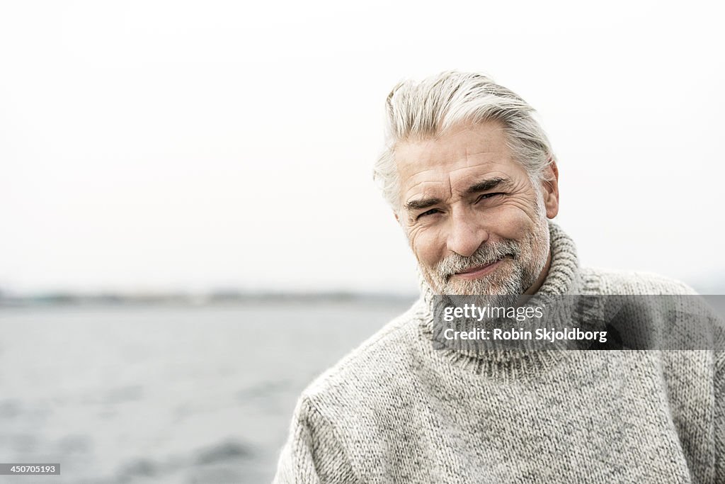 Mature grey haired man wearing a sweater