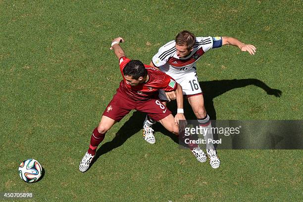 Joao Moutinho of Portugal holds off a challenge by Philipp Lahm of Germany during the 2014 FIFA World Cup Brazil Group G match between Germany and...