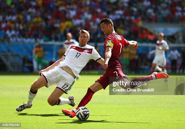 Cristiano Ronaldo of Portugal shoots against Per Mertesacker of Germany during the 2014 FIFA World Cup Brazil Group G match between Germany and...