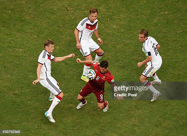 Joao Moutinho of Portugal takes on Toni Kroos of Germany, Mario Goetze and Philipp Lahm during the 2014 FIFA World Cup Brazil Group G match between...