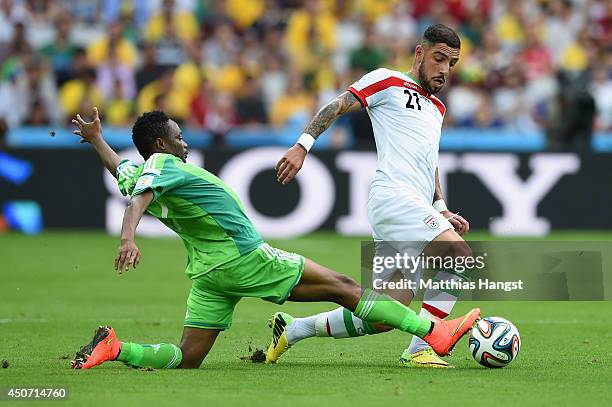 Ashkan Dejagah of Iran is challenged by Ahmed Musa of Nigeria during the 2014 FIFA World Cup Brazil Group F match between Iran and Nigeria at Arena...