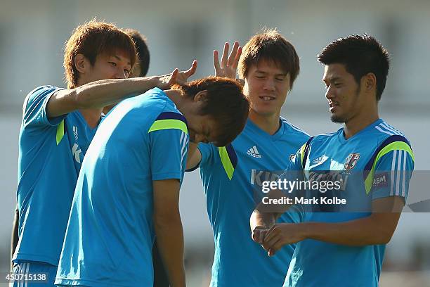 Hiroki Sakai is flicked by team mates after losing a game during warm-up for a Japan training session at the Japan national team base camp at the Spa...