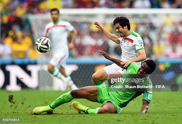 Khosro Heydari of Iran and John Obi Mikel of Nigeria challenge for the ball during the 2014 FIFA World Cup Brazil Group F match between Iran and...