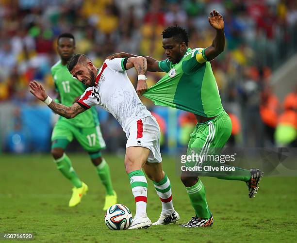 Ashkan Dejagah of Iran pulls the jersey of Joseph Yobo of Nigeria during the 2014 FIFA World Cup Brazil Group F match between Iran and Nigeria at...