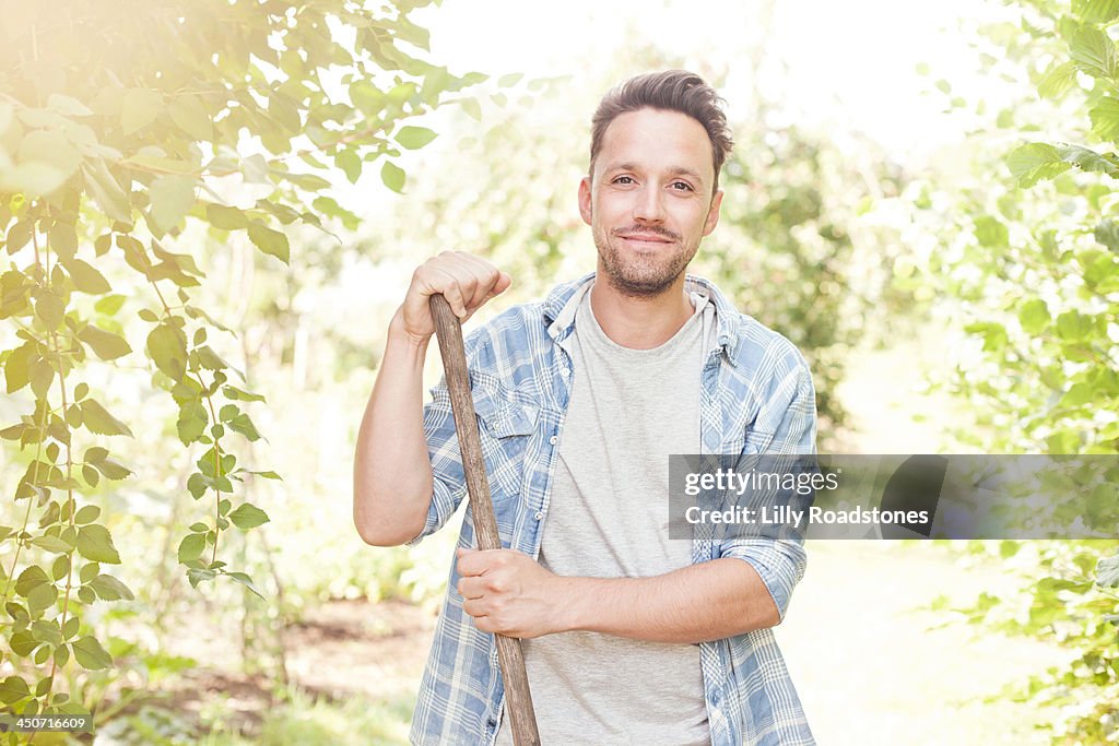 One man leaning on hoe in allotment