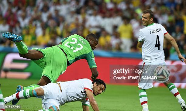Nigeria's forward Shola Ameobi fights for the ball with Iran's defender Amir Hossein Sadeqi and Iran's defender Jalal Hosseini during a Group F...