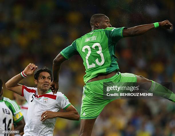 Iran's defender Amir Hossein Sadeqi fights for the ball with Nigeria's forward Shola Ameobi during a Group F football match between Iran and Nigeria...