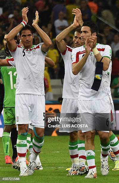 Iran's defender Amir Hossein Sadeqi, defender Jalal Hosseini and midfielder Javad Nekounam acknowledge supporters at the end of the Group F football...