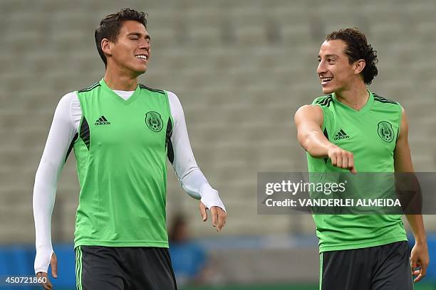 Mexico's defender Andres Guardado talks to Mexico's midfielder Javier Aquino during a training session at the Castelao Stadium in Fortaleza on June...