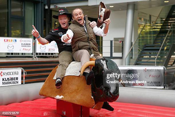 Moderator Wolfram Kons and Joey Kelly pose on a bull riding machine during a photocall on November 20, 2013 in Cologne, Germany. Joey Kelly will go...