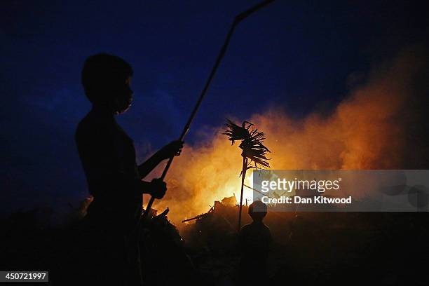 Boy burns wood on a fire near the Tacloban astrodome evactuatuion centre on November 20, 2013 in Leyte, Philippines. Typhoon Haiyan which ripped...