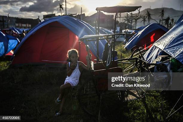 Girl sits outside her tent at the Tacloban astrodome evactuatuion centre on November 20, 2013 in Leyte, Philippines. Typhoon Haiyan which ripped...