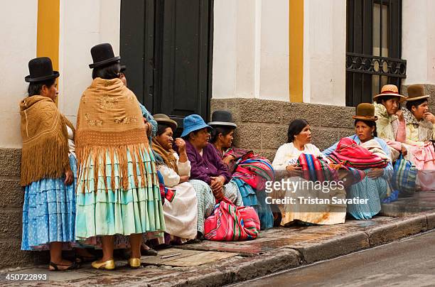 Indigenous Quechua women waiting in front of a Bolivian Government building, in La Paz. Those Quechua women wear the colorful traditional costume,...