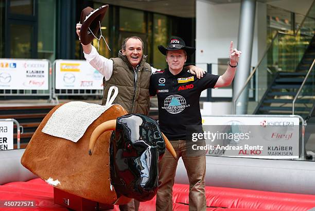 Moderator Wolfram Kons and Joey Kelly pose on a bull riding machine during a photocall on November 20, 2013 in Cologne, Germany. Joey Kelly will go...