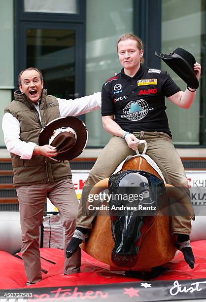 Moderator Wolfram Kons and Joey Kelly pose on a bull riding machine during a photocall on November 20, 2013 in Cologne, Germany. Joey Kelly will go...