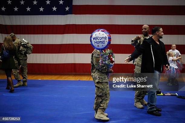 Pfc. Tyra Guy of the U.S. Army's 3rd Brigade Combat Team, 1st Infantry Division, holds a bouquet of flowers and a balloon given to her by her fiance...