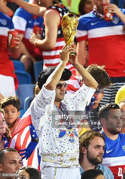 United States fan dressed as Elvis holds a replica World Cup trophy during the 2014 FIFA World Cup Brazil Group G match between Ghana and USA at...