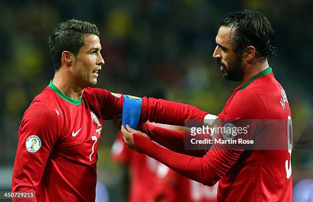 Huga Almeida helps Cristiano Ronaldo of Portugal with his captains bandage runs with the ball during the FIFA 2014 World Cup Qualifier Play-off...