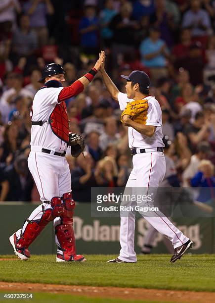 Koji Uehara of the Boston Red Sox celebrates a victory with teammate A.J. Pierzynski after the ninth inning against the Minnesota Twins at Fenway...
