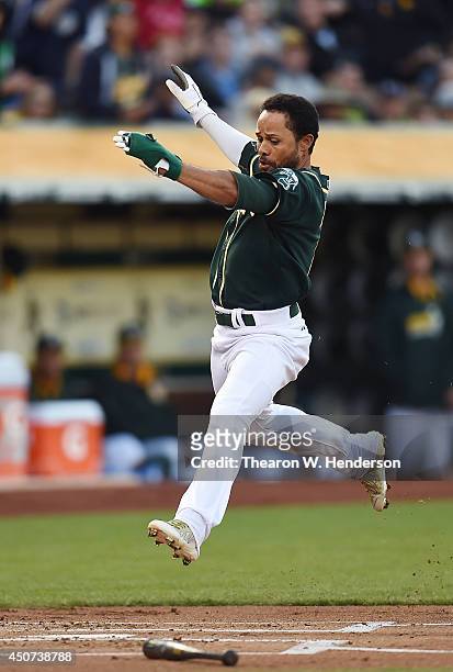 Coco Crisp of the Oakland Athletics scores in the bottom of the first inning against the Texas Rangers at O.co Coliseum on June 16, 2014 in Oakland,...