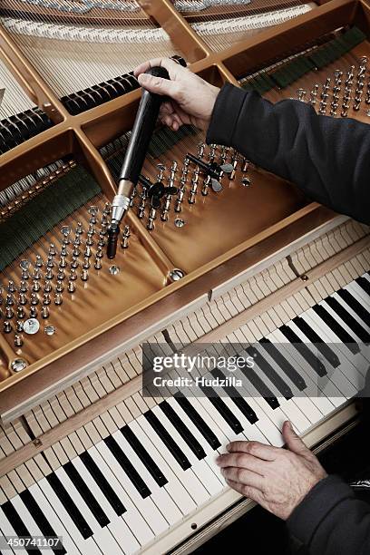 a repairman working on a grand piano - grand piano film stock-fotos und bilder
