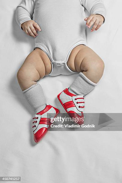 a baby boy wearing baby soccer shoes, waist down - red shoe stock pictures, royalty-free photos & images