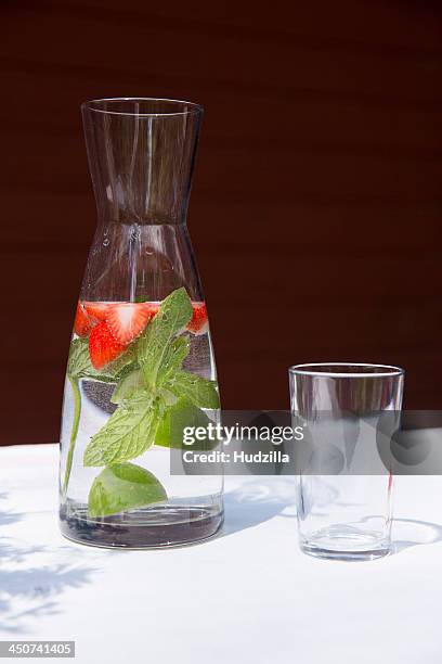 a carafe of water with sliced strawberries and mint leaves - carafe stock pictures, royalty-free photos & images