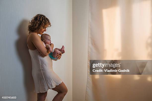 mother holding baby - see through negligee stock pictures, royalty-free photos & images