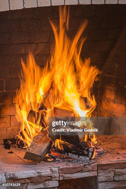 a stack on fire wood ablaze in an open fire - warming up stock pictures, royalty-free photos & images