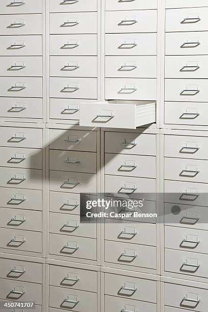 A white cabinet of drawers with one drawer open