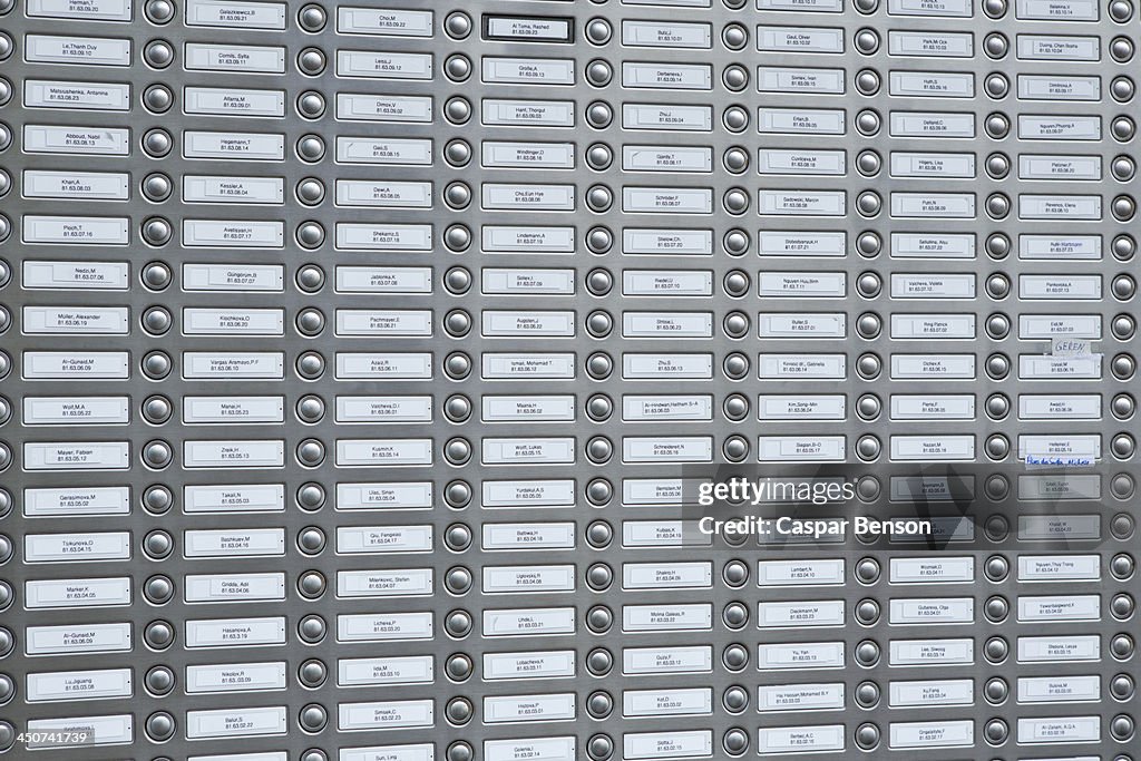 Rows of doorbells on a metal panel