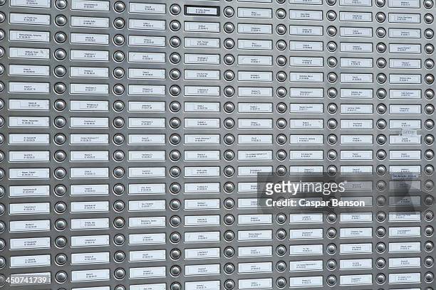 rows of doorbells on a metal panel - doorbell stock-fotos und bilder