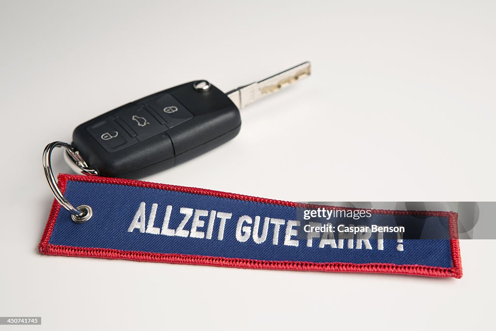 A car key and keychain with the phrase Always Drive Good in German Allzeit Gute Fahrt!
