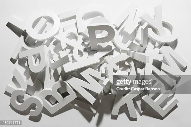 a pile of various white block letters from the alphabet - alfabeto fotografías e imágenes de stock