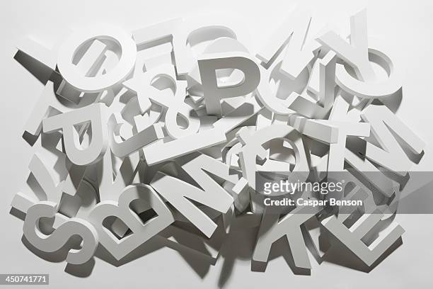 a pile of various white block letters from the alphabet - testo foto e immagini stock